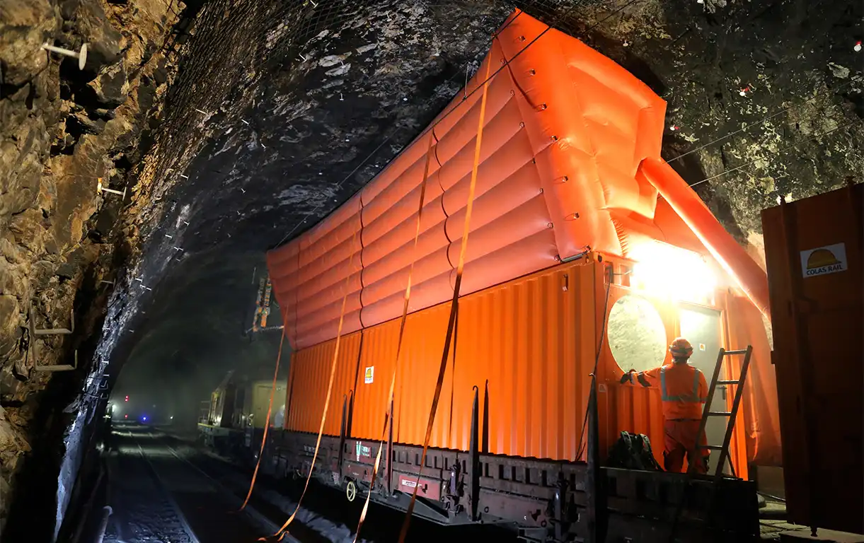 Un abri gonflable orange dans un tunnel pour protection du personnel dans un chantier souterrain